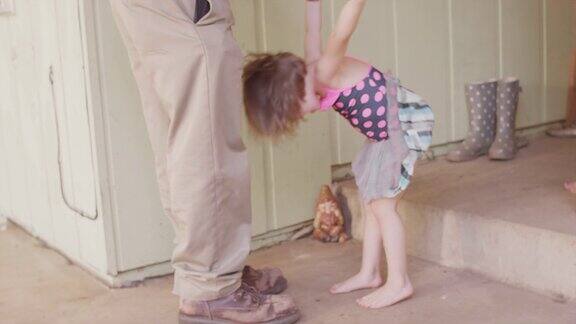 穿着芭蕾舞裙的小女孩爬上爸爸身上翻转