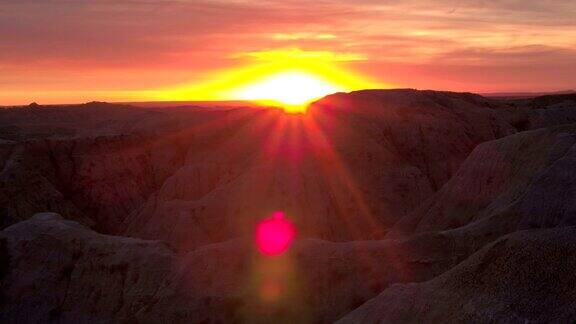 AERIAL:Badlands公园砂岩山背后令人惊叹的红色日落