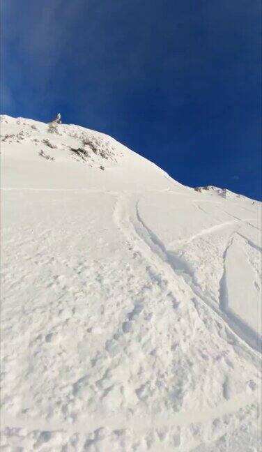 垂直视频POV拍摄的自由式滑雪运动员下降积雪覆盖的斜坡