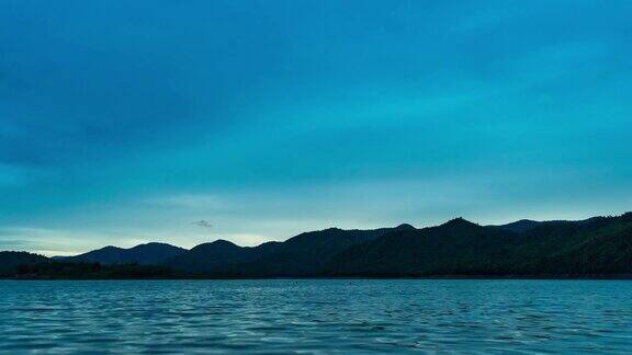 从白天到黄昏的时间流逝宁静的湖与热带山脉的背景在日落
