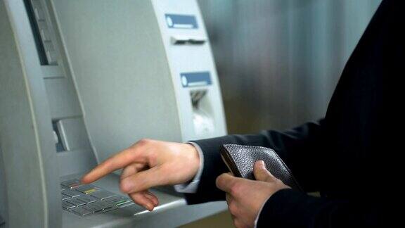 商人将信用卡插入ATM机输入密码收钱