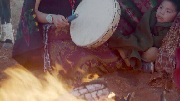 纳瓦霍土著美国兄弟姐妹呆在篝火旁的特写视频一个姐妹打鼓纪念碑谷部落公园亚利桑那州在日落