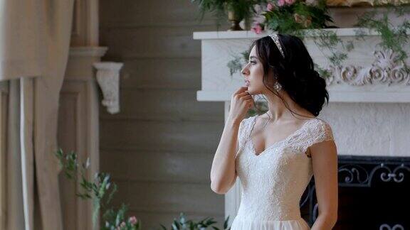 穿着白色婚纱的新娘待在室内为摄影师摆姿势