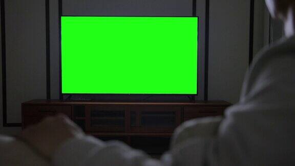 男人在看绿色屏幕的电视