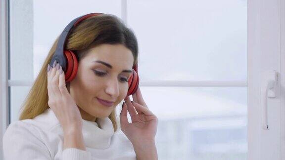 迷人的金发美女戴着耳机喜欢听音乐