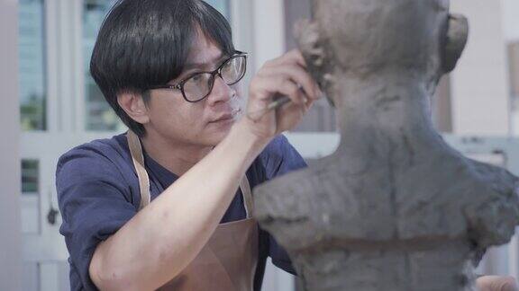 亚洲人雕塑家创造一个泥塑