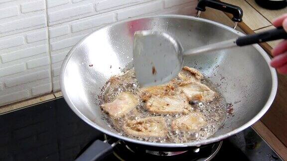 用热油在锅里炸猪肉