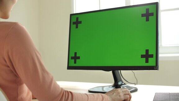 一名妇女在家中用她的色度键电脑工作