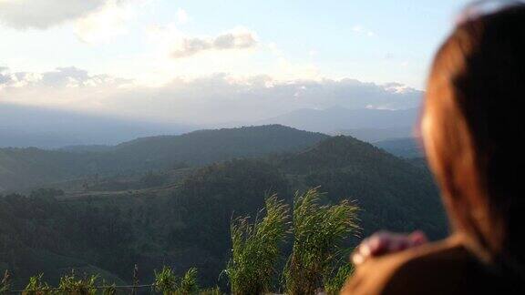 模糊的后视图一个女性旅行者在看一个美丽的绿色山景