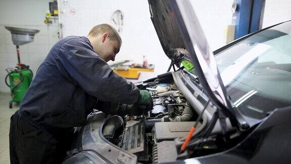 汽车修理工在汽车引擎盖下的车库工作维修服务