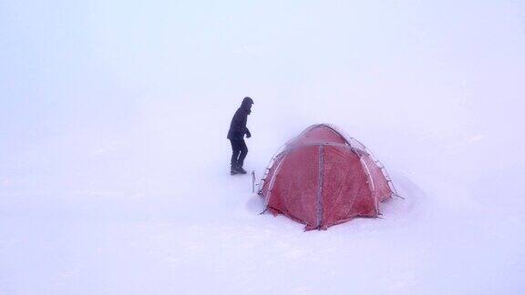 冬季日出时高山攀登者要到高海拔的山顶搭帐篷