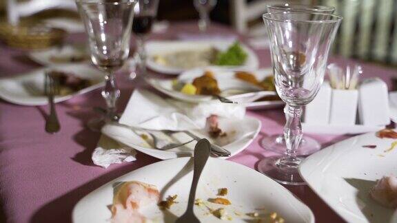 剩下的食物在盘子里和脏餐巾在桌子上