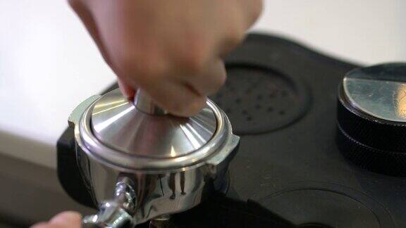 4K年轻的亚洲男子咖啡师正在用咖啡机手工制作热咖啡