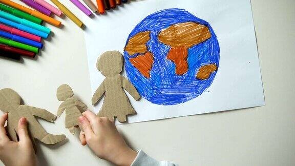 孩子们把纸上的家庭和心形标志放在地球附近画拯救地球