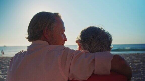 一对老年夫妇在夏天的海滩上放松