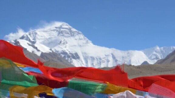近距离:彩旗在远处被风吹拂的珠穆朗玛峰前飘扬