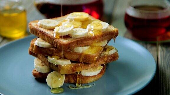新鲜的自制酥脆吐司配蜂蜜和香蕉在蓝色盘子里美味的早餐