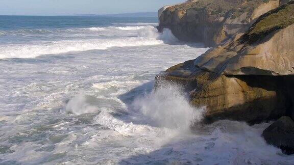 新西兰奥塔哥半岛隧道海滩海浪冲击悬崖的慢镜头