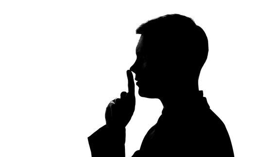 男人表现出沉默的姿态不泄露机密数据手指放在嘴唇上
