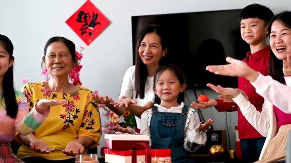 三代快乐的亚洲家庭庆祝中国新年享受传统食物和聚会在客厅