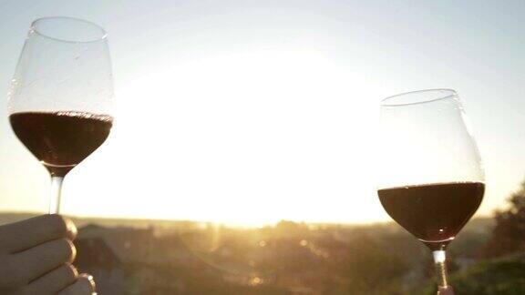夕阳下互相碰杯的红酒