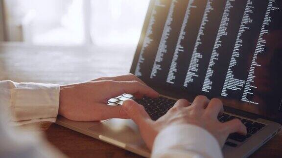 男人的双手在家里的笔记本电脑上编程特写使用便携式电脑的人程序员编写代码