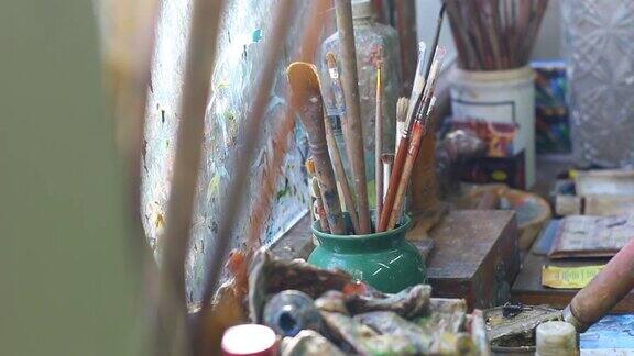 旧木桌上的艺术画笔和调色板刀