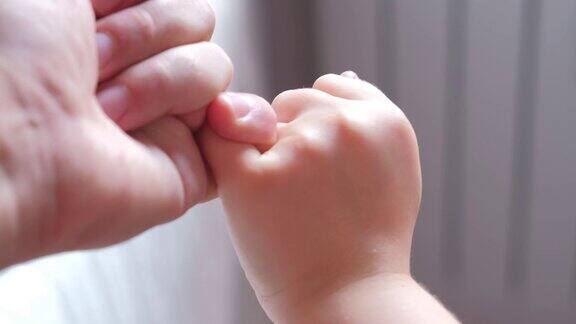 白种人父亲和孩子用手指做小指发誓手势