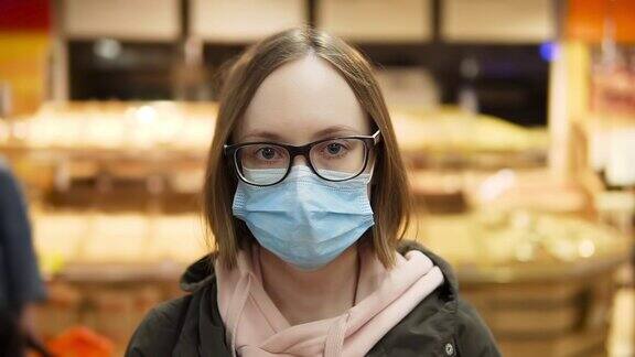 戴着医用防护口罩和眼镜的女人肖像超市的慢镜头特写