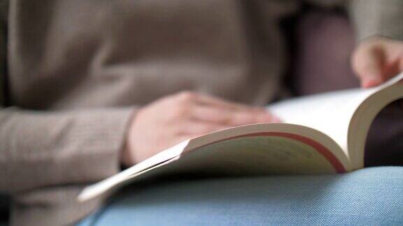 近距离的女人阅读一本书在放松的时间在家里
