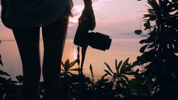 女孩用单反相机拍摄日落