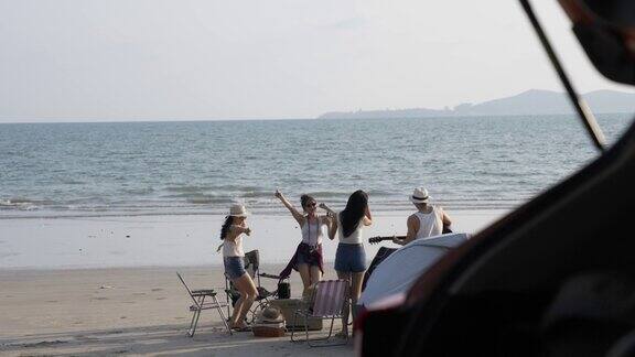 一群亚洲朋友在海滩上露营度假