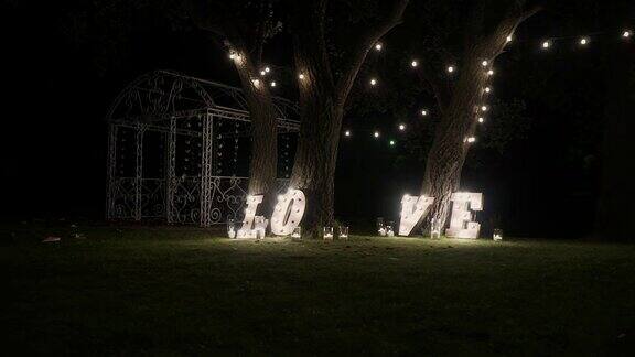 木制字母和灯泡字爱舞台上照亮的“爱”字“爱”字由灯光铺在光滑的地板上组成