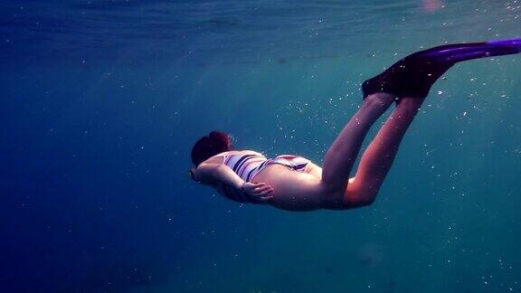 女孩在红海的珊瑚礁附近潜水