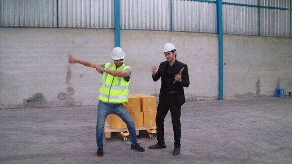 滑稽的工厂工人在工厂里跳舞
