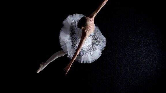 穿着芭蕾舞裙的年轻女芭蕾舞者的剪影正在从一个角落到另一个角落移动和旋转芭蕾舞概念运动概念顶部镜头