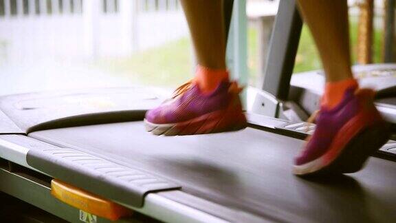 女人在一个健身房跑步机概念运动健身和健康的生活方式