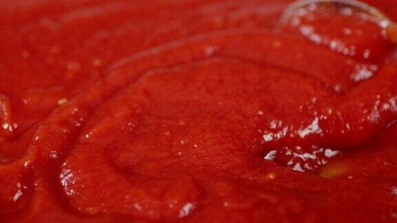 用勺子搅拌的番茄酱