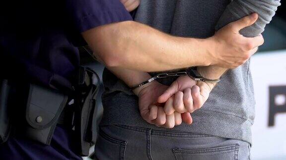 警察拘留了罪犯并给他戴上手铐去了警察局