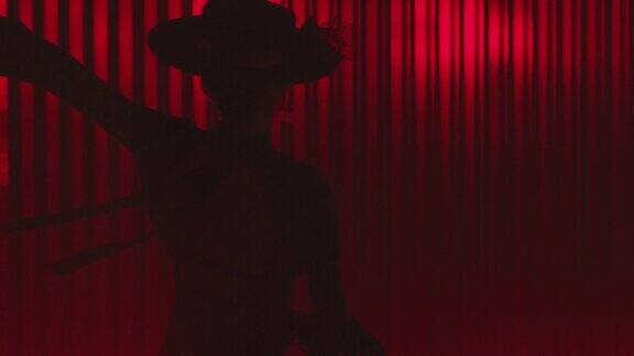 漂亮的帽子打扮的女孩跳拉丁舞专业女舞者在红色背景和线条上跳弗拉门戈、伦巴或萨尔萨舞西班牙舞蹈动作射击ARRIALEXA电影摄像机