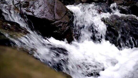 美丽的山瀑布水在石头间流动