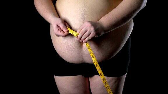 超重男子用卷尺量肚子体重减轻营养不良