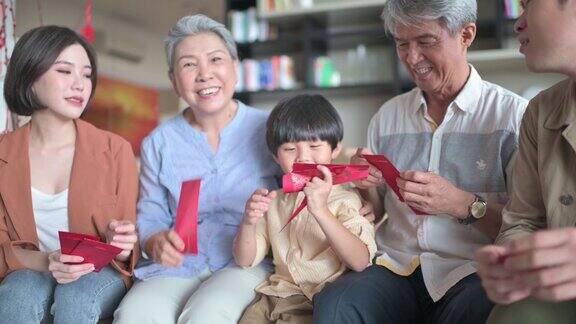 春节家人团聚夫妇带着孩子去爷爷奶奶家给父母红包给父母繁荣幸福
