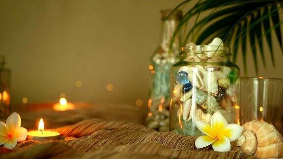 玻璃瓶里装满了贝壳珊瑚用蜡烛鸡蛋花装饰的海洋物品