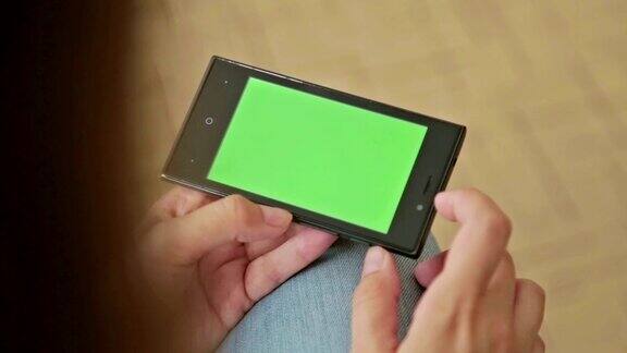 手持绿色屏幕智能手机的漂亮女人