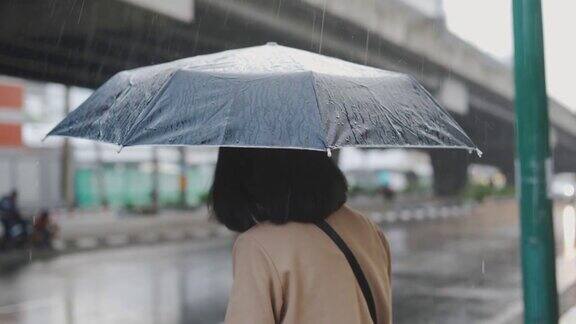 一个亚洲女人在雨中等出租车