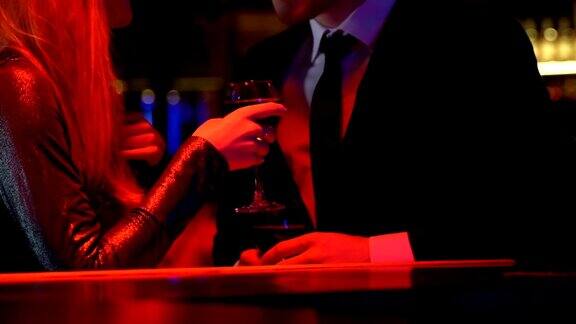 年轻女子与男子在夜总会调情夫妇享受与葡萄酒约会