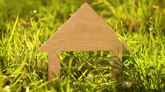 木房子模型矗立在绿色的草地上