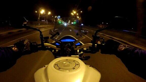 一个骑摩托车的人在傍晚的城镇公路上高速行驶的观点摩托车在空旷的城市街道上行驶的观点观点关闭