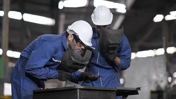 技术工人和生产线机器一起工作的焊工